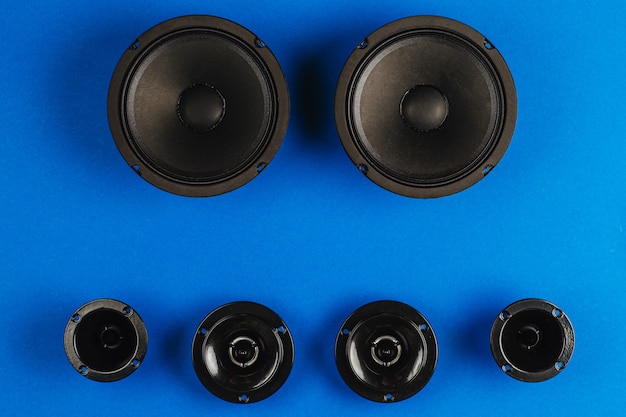 Altavoces de coche de audio de coche subwoofer negro sobre un fondo azul.