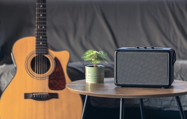 Altavoz de música y guitarra acústica en el interior de la habitación