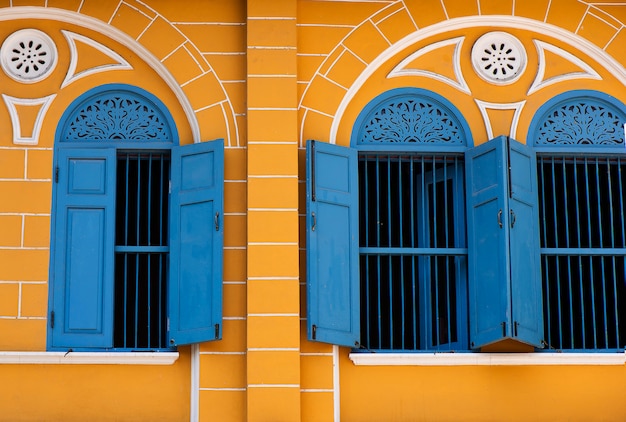 Altbau mit blauem Fenster und gelben Gebäuden