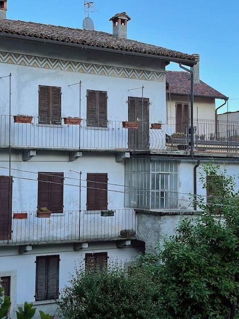 Alte antike historische Architektur in Italien. Traditionelle europäische Gebäude mit Holzfenstern, Fensterläden und pastellfarbenen Wänden. Sommerferien-Reisekonzept