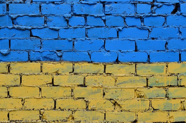 Alte Backsteinmauer gemalt in den Farben der ukrainischen Flagge