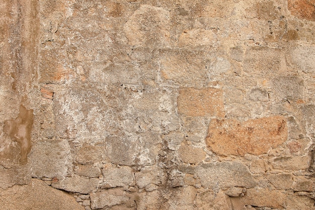 Alte beige Steinwand-Hintergrundbeschaffenheit