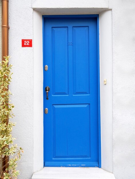 Alte blaue Holztür in weißer Wand