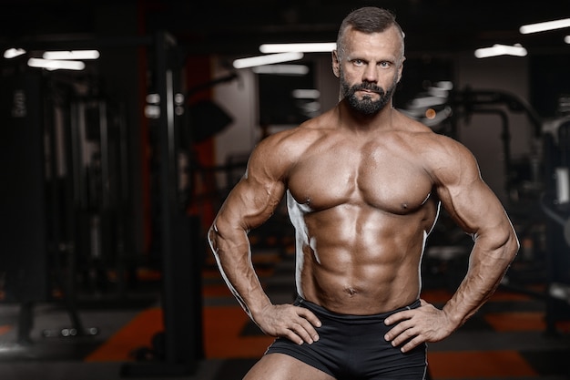 Alte brutale starke Bodybuilder-Sportler, die Muskeln mit Hanteln aufpumpen