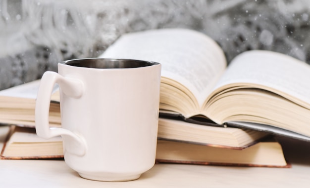 Alte Bücher auf Holztisch und Tasse Kaffee.