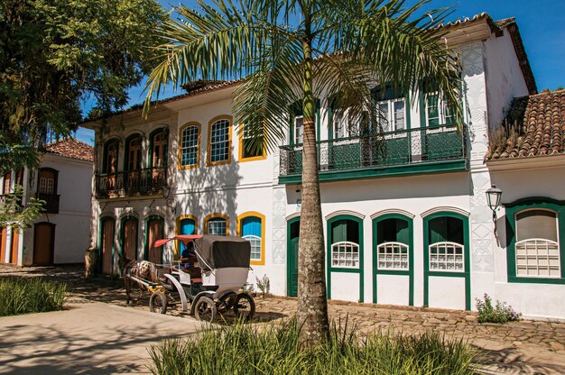 Foto alte farbige häuser, palmenwagen und kopfsteinpflaster in paraty, brasilien