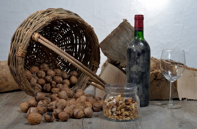 Alte Flasche Wein mit einem Korb von Nüssen