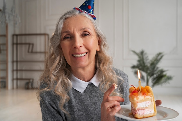 Alte Frau des mittleren Schusses, die Kuchen hält