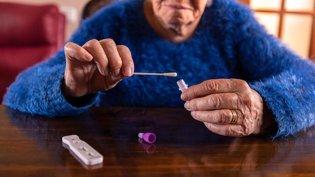 Alte Frau, die einen Wattestäbchen für die Nase hält, um ein mögliches positives COVID19 zu sammeln