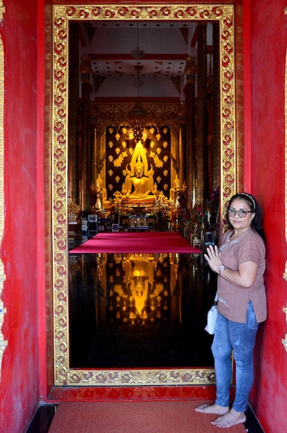 Alte Frau, die mit Reflektion betet Goldene Buddha-Statue in der Kirche von Wat Phra That Suthon Mongkhon Khiri in Phrae Thailand