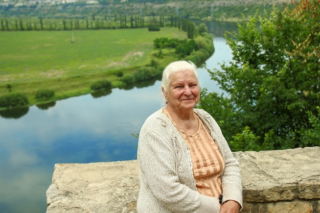 Alte Frau in der Nähe der Flussträume erinnert sich an das Leben