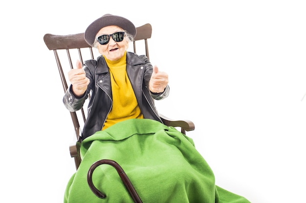 Alte Frau mit Sonnenbrille auf einem Stuhl sitzend