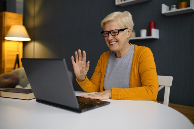 Alte Frau mit Videokonferenz auf dem Laptop