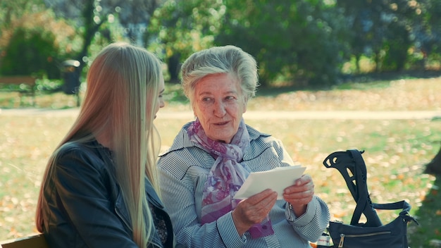 Alte Frau zeigt ihrer hübschen Enkelin einen Brief
