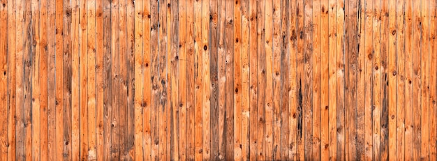 Alte gelbe Holzwand, gealtert im Regen und in der Sonne. Natürlicher abstrakter Plankenhintergrund.