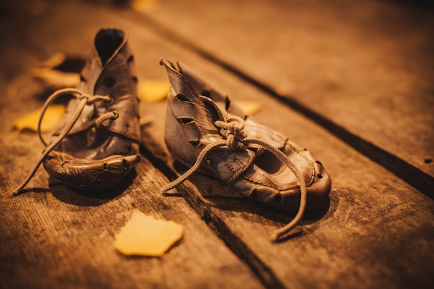 Alte getragene Babyschuhe auf der Bürgersteigfliese. Das Konzept der Armut