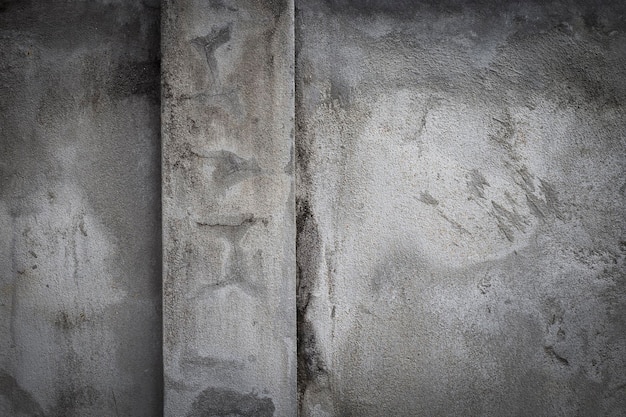 Alte graue Zementwand mit Rissen an der Oberfläche