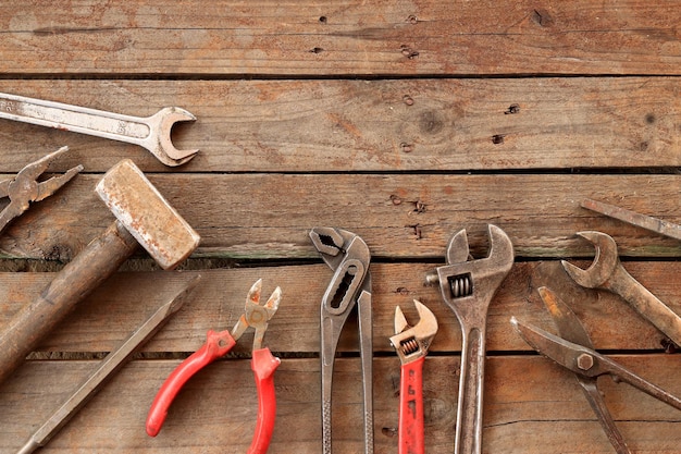 Alte Handwerkzeuge auf einer hölzernen Oberfläche Oberansicht Verstellbares Schraubenschlüsselhammer Schlaghammer Zinnschnitte und Zangen Werkzeuge für Reparatur und Bau Holzboden und Werkzeuge