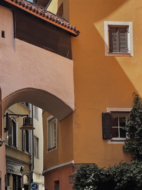 Alte historische Architektur in Italien Traditionelles europäisches Altstadtgebäude Holzfensterläden und farbenfrohe pastellfarbene Wände mit Sonnenlichtschatten Ästhetischer Sommerurlaub Reiserückgrund