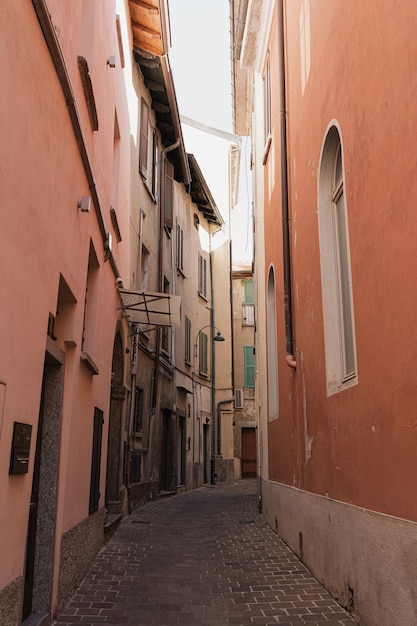 Alte historische italienische Architektur Traditionelle europäische Altstadtgebäude Holzfensterläden und pastellfarbene Korallenwände mit Sonnenlichtschatten Ästhetischer Sommerurlaub Reisehintergrund