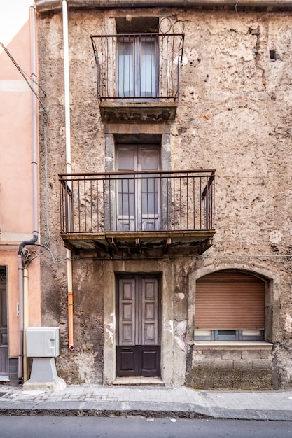 Alte hölzerne Eingangstür an der Fassade des antiken barocken Gebäudes in der traditionellen Architektur von Catania Sizilien, Italien.