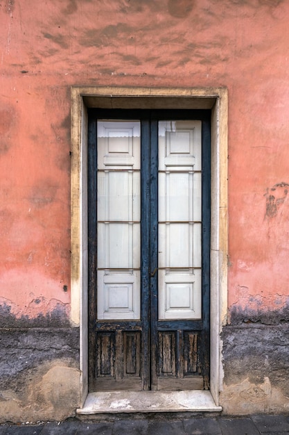 Alte hölzerne Eingangstür an der Fassade des antiken barocken Gebäudes in der traditionellen Architektur von Catania Sizilien, Italien.