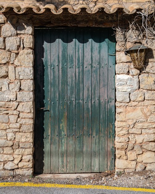 Alte hölzerne grüne Tür mit Eisengriff in einer Steinmauer Mallorca Balearen Spanien