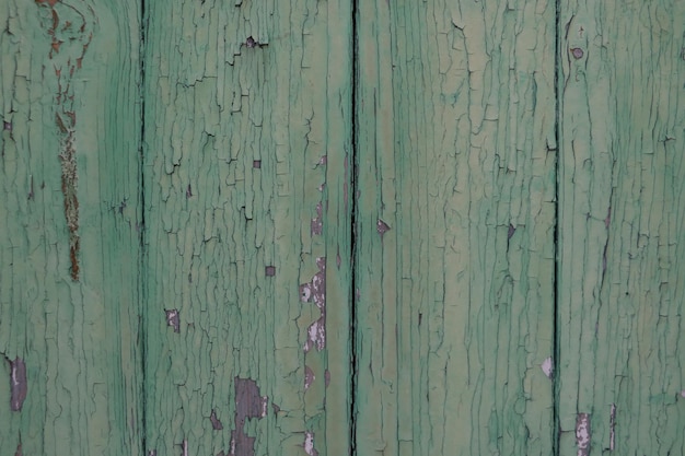 Alte Holzstruktur mit abblätternder grüner Farbe im Hintergrund