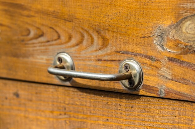 Alte Holztür mit einem Griff im Hintergrund.