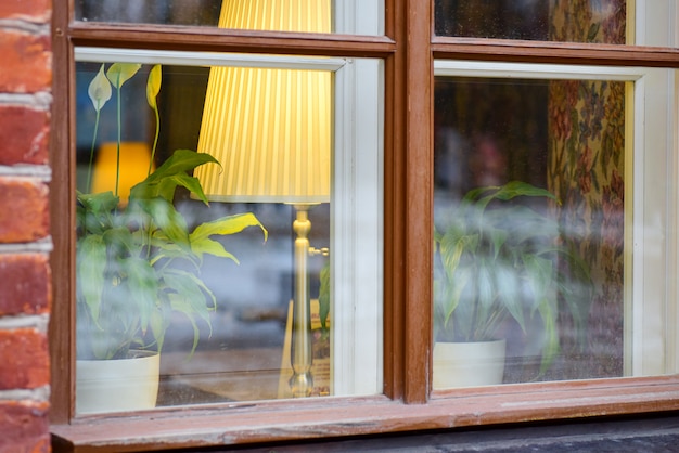 Alte Lampe auf dem Tisch vor dem Fenster