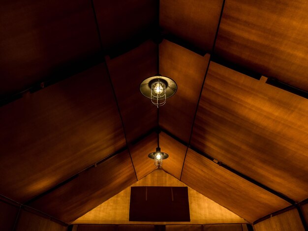 Alte Lampe im Retro-Stil, die bei einer Nacht an der Decke im großen Glamping-Zelt hängt Beleuchtung im Zelt