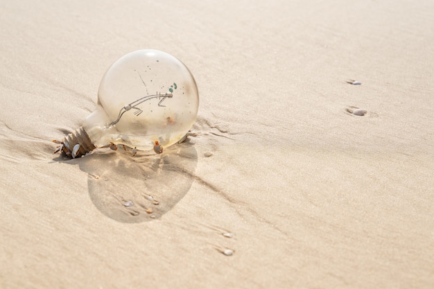 Alte Lampe mit Rost an einem Strand mit gelbem Sand.