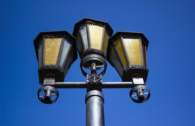 Alte Laternenpfähle am Nachmittag gegen den Himmel. Ausgeschaltete Vintage-Lampen