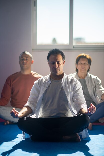 Alte Menschen üben Meditation im Fitnessstudio