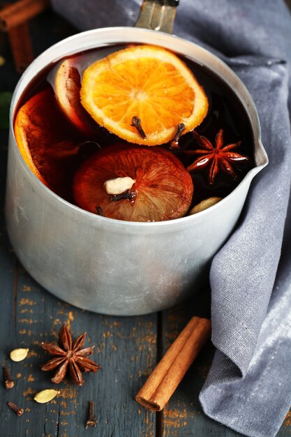 Alte Metallpfanne mit leckerem Glühwein auf Holztisch