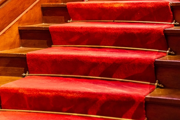 Foto alte mit teppich ausgelegte treppe mit rotem teppich und holzboden drei