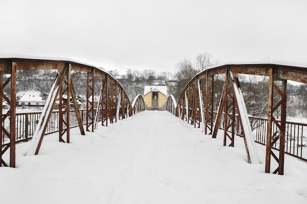 Alte Stahlstraßenbrücke über Fluss nach Schneefall