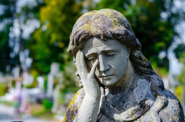 Alte Steinstatue auf dem Friedhof traurige Steinfrau