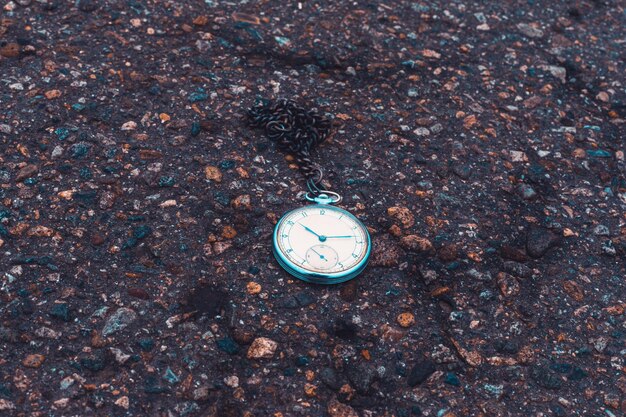 Alte Taschenuhr auf dem Boden Zeitkonzept