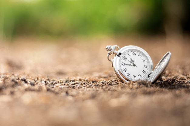 Foto alte taschenuhr wird auf dem boden weggeworfen. denken und steuern timing-ideen-konzept.