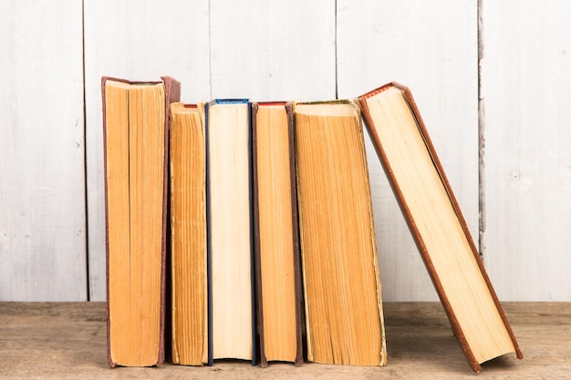Alte und gebrauchte Hardcover-Bücher oder Textbücher auf Holzhintergrund