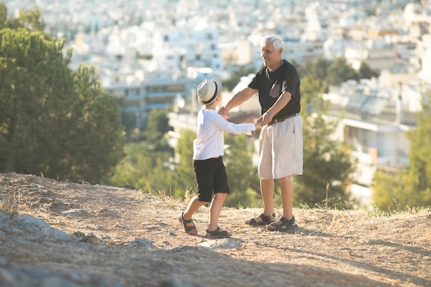 Alte und junge Familiengeneration und Beziehungskonzept. Großvater und Enkel im Ruhestand spielen an einem sonnigen Tag im Freien