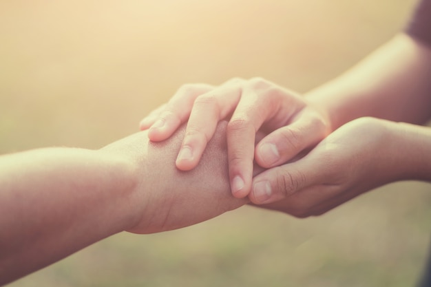 Alte und junge Hand der Leute, die Hoffnung halten