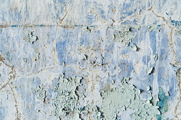 Alte und schmutzige bröckelnde Wand mit abblätternder Farbe und Rissen Textur Grunge Innenraum Hintergrund Nahaufnahme