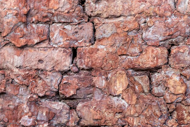 Alte verlassene Backsteinmauer mit gebrochener rauer Putzoberfläche für Hintergrund