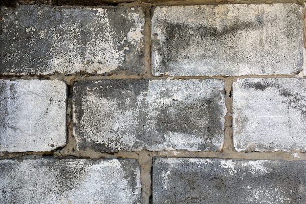 Foto alte vintage retro-stil graue mauer an der straße, altersschwach mit der zeit. abstrakter ziegelsteinhintergrund und -beschaffenheit. nahaufnahme. draußen.