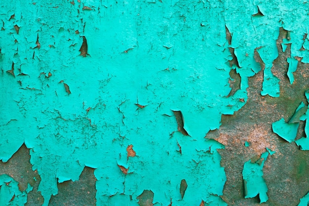 Foto alte wand mit schälender farbe türkisfarbene ölfarbe, die auf einer holzoberfläche geknackt ist