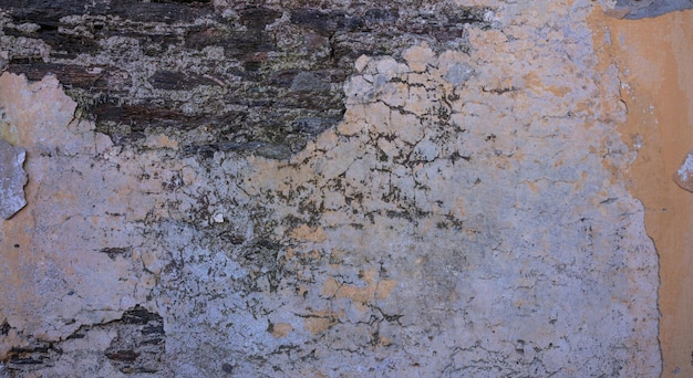 Alte Wandfassade aus beunruhigtem Stein Gemalter und verblasster orangefarbener Mauerwerk-Texturhintergrund