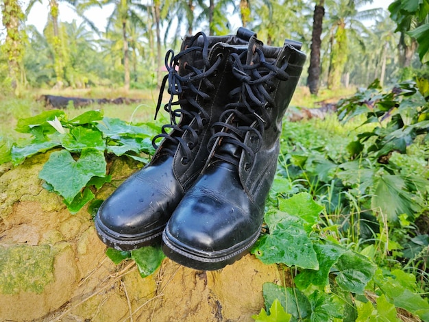 Foto alte weggeworfene lederstiefel in der wilden wiese gefunden