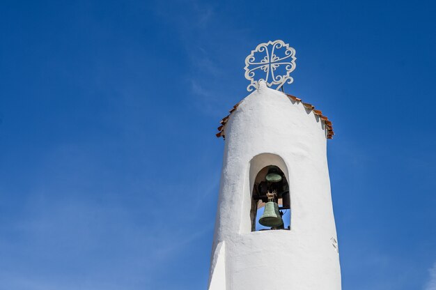 Foto alte weiße glockenturmnahaufnahme gegen den blauen himmel. porto cervo, sardinien. platz kopieren